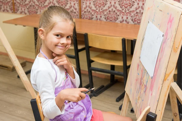 Chica artista con una sonrisa mirada en la imagen en la lección de dibujo —  Fotos de Stock