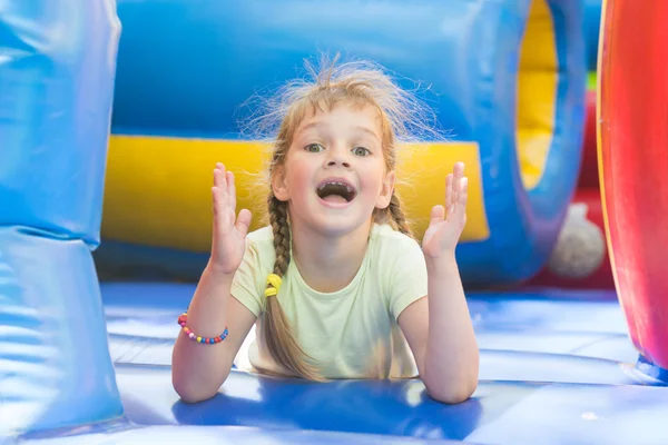 Szczęśliwa dziewczyna leżąc na grę big trampoliny nadmuchiwane — Zdjęcie stockowe