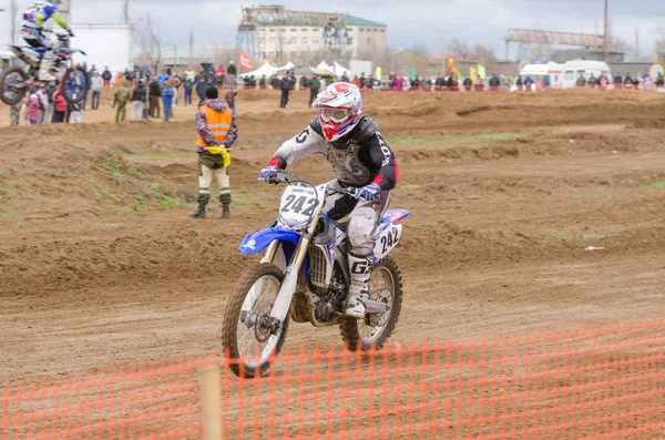 Volgograd, Russia - April 19, 2015: Motorcycle racer racing on the track, the spectators in the background, at the stage of the Open Championship Motorcycle Cross Country Cup Volgograd Region Governor