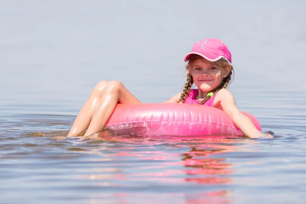 A menina no chapéu nadou no rio sentou-se no colo nadando e olhou para a moldura — Fotografia de Stock