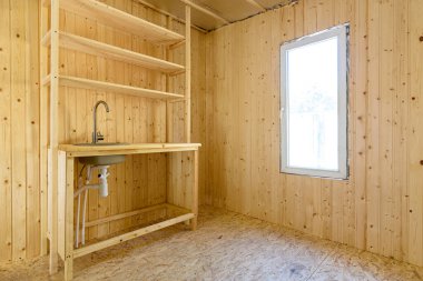 Yeni bir çerçeve kır evinin iç kısmında küçük bir mutfak.