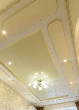 Orijinal, çok katlı tavan, yatak odasında altın tonlarda.