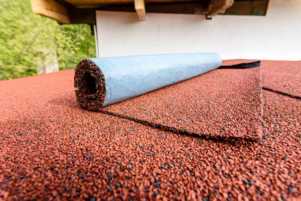 Red flexible roll tile on the roof of the house