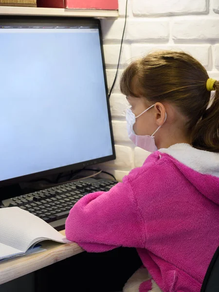 Dziewczyna Masce Medycznej Siedzi Przy Komputerze Uczy Się Online — Zdjęcie stockowe