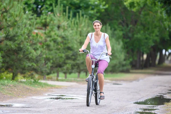 雨の暖かい夏の朝に自転車に乗る女の子 — ストック写真