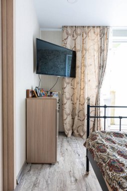 Anapa, Russia - 23 August 2020: A fragment of the interior of a small bedroom, in the corner there is a bedside table and a TV clipart