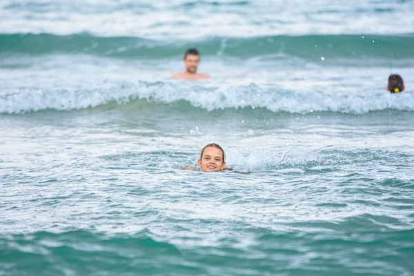 一个女孩在海里游泳 还有几个人在后面游泳 — 图库照片