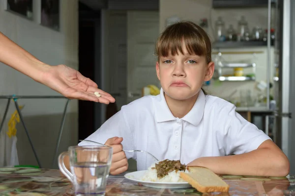 女の子は夕食前に母親が提供する薬が好きではありません — ストック写真