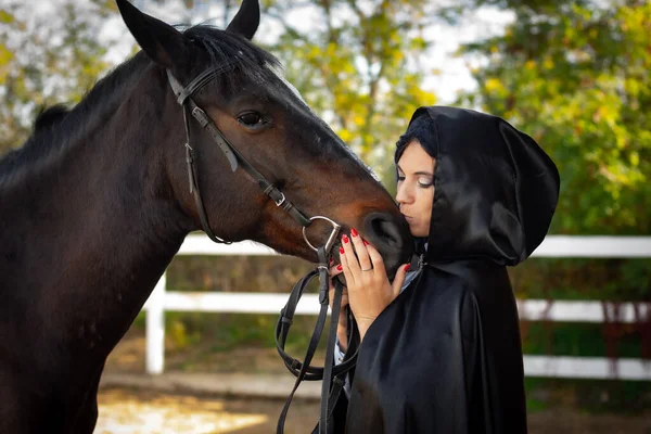 Meisje Een Zwarte Mantel Knuffelt Kust Een Paard — Stockfoto