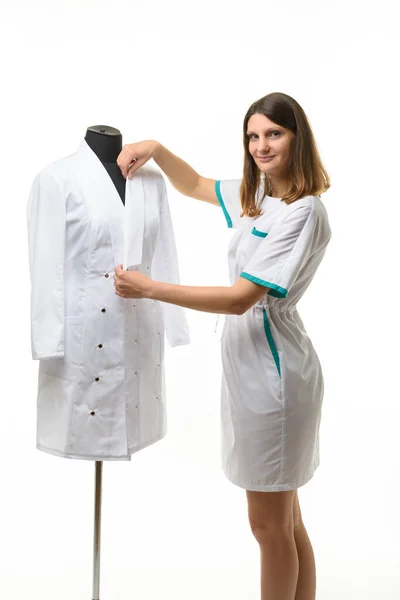 Medical Gown Hangs Mannequin Girl Nurse Straightens Collar Gown — Stock Photo, Image