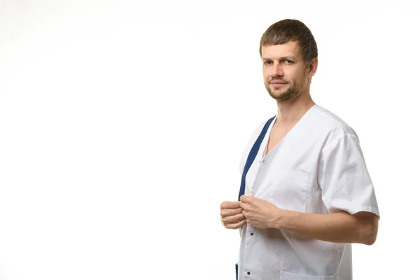 白い背景に隔離された医療シャツの医師の固定ボタン — ストック写真