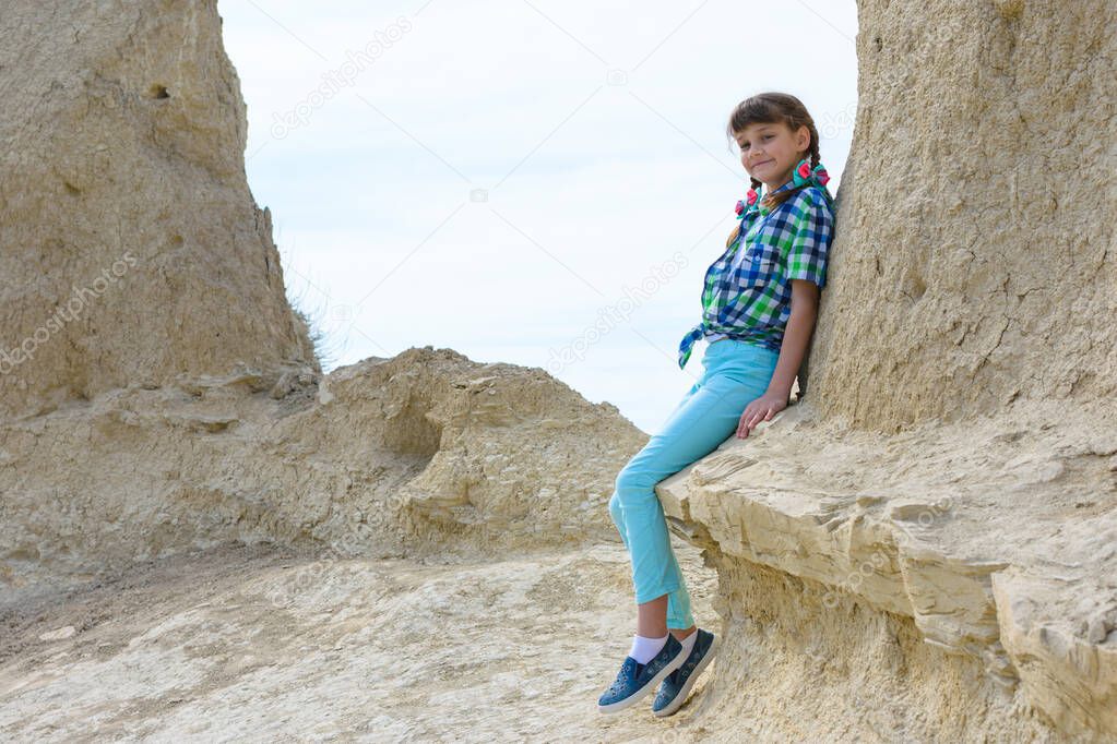 A ten-year-old girl sat down on a rock ledge