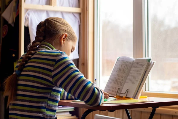 Flicka Gör Läxor Sittandes Vid Bordet Vid Fönstret — Stockfoto