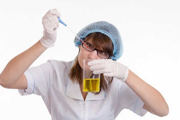 Chemist finds drops falling into a flask — Stock Photo, Image