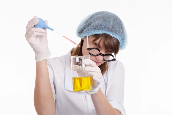 Assistente de laboratório líquido goteja de uma pipeta em frasco — Fotografia de Stock