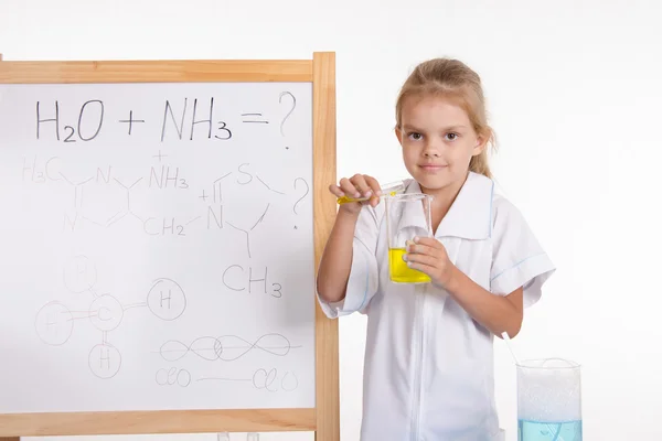 女孩显示化学经验站在黑板前 — 图库照片