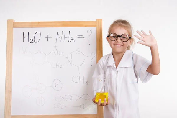 Meisje scheikundige kolf op een bord met inscriptie — Stockfoto