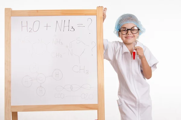 Pharmacist standing at the blackboard with a test tube — Stock Photo, Image