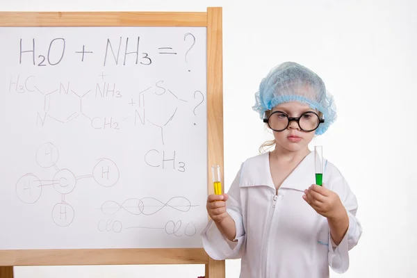 Chemist girl in points and with two tubes at board — Stock Photo, Image