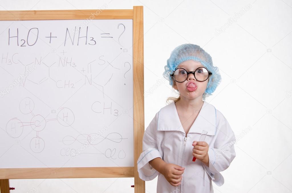Girl chemist at the blackboard showing tongue