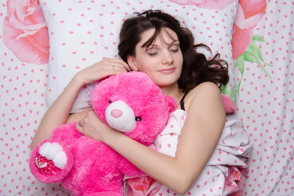 Mädchen umarmt Teddybär im Traum — Stockfoto