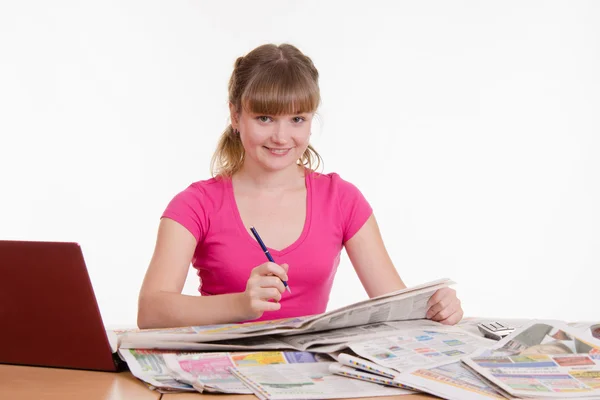 Chica buscando en el periódico anuncios clasificados — Foto de Stock