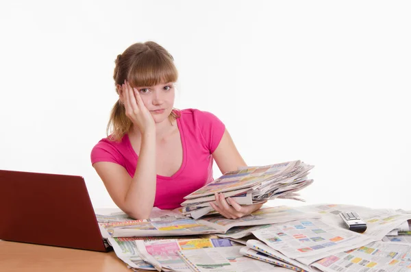 Sad girl with a stack of newspapers — Stock Photo, Image