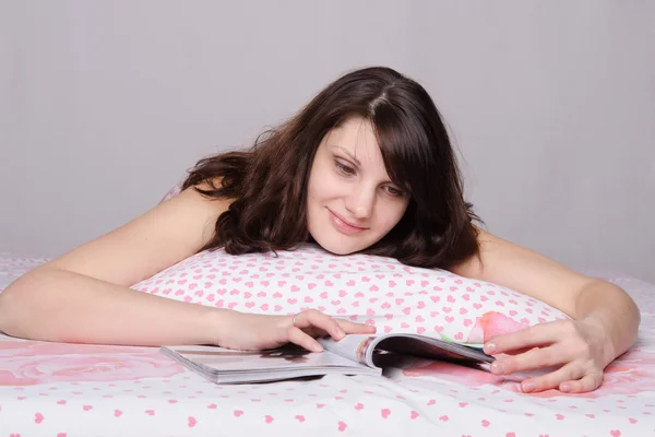 Chica con sonrisa leyendo un artículo de la revista — Foto de Stock