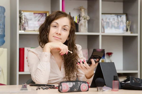 The girl is engaged make-up in workplace — Stock Photo, Image