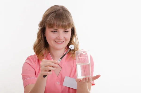 Student pharmacist throws pill to liquid water — Stock Photo, Image
