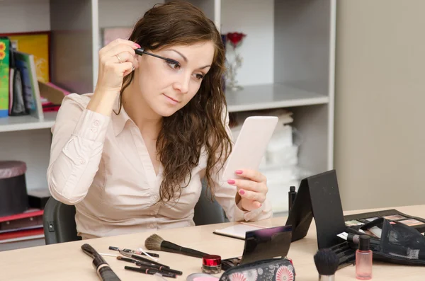 Girl in the office paints eyelashes — Stock Photo, Image