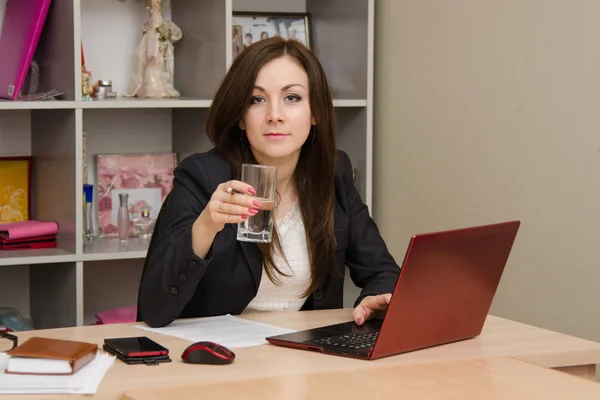 Zakenvrouw op de computer met een glas water — Stockfoto