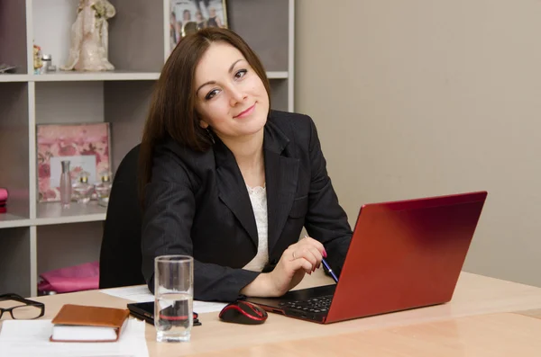 Bilgisayar başında gülümseyen iş kadını — Stok fotoğraf