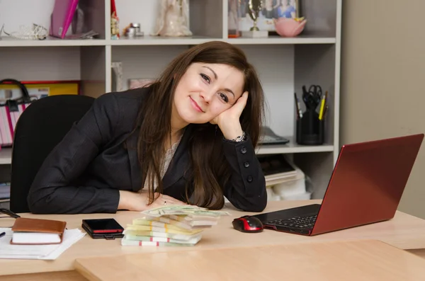 Pretty teenage girl in the office with a bundle of banknotes — Stock Photo, Image