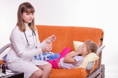 Doktor küçük bir kız bir enjeksiyon yapmak hazırlanıyor