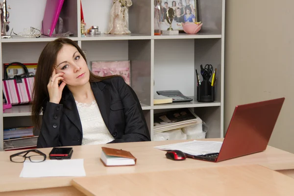 Girl in the office sitting a table at computer and head support arm — Stock Photo, Image