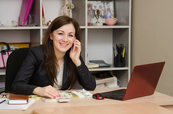 Девушка и офис разговаривают по телефону глядя в рамку улыбаясь Лицензионные Стоковые Изображения