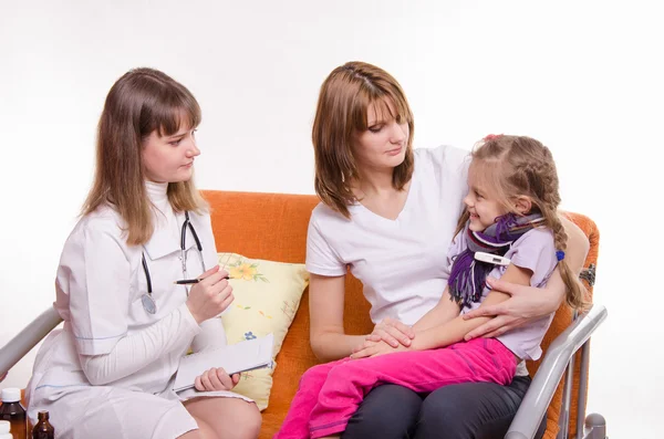 Ziek meisje, zittend op de schoot van moeder en kinderarts inspectie — Stockfoto