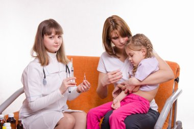 Çocuk doktoru shot hasta bir çocuğun annesi ellerde oturan olacak