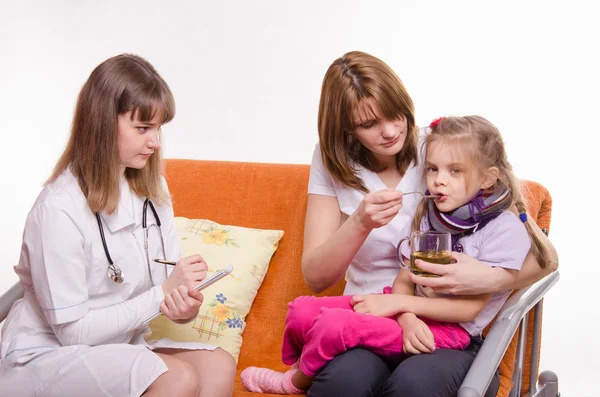 Çocuk doktoru reçete tedavi çocuk annesi bir kaşık gelen çay içmek için verir — Stok fotoğraf