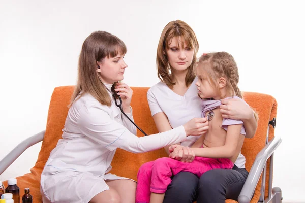 小児科医が呼吸聴診器母の腕の中で小さな女の子をチェックします。 — ストック写真