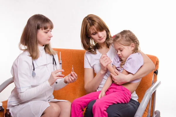 Bir şırınga hasta çocuk annesi ellerde oturan için tutan çocuk doktoru