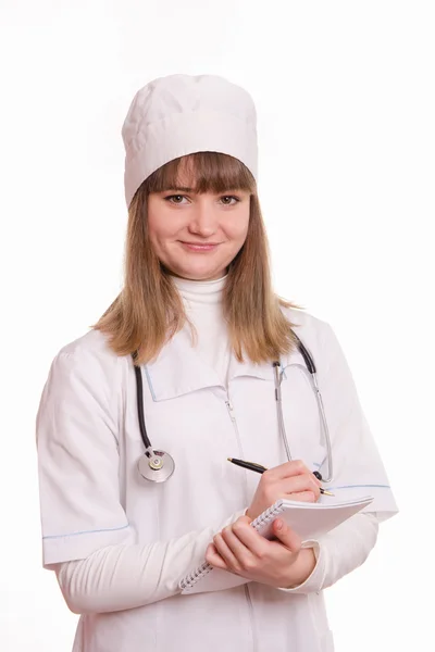 Oficial médico con una bata blanca escribe en un cuaderno de información — Foto de Stock