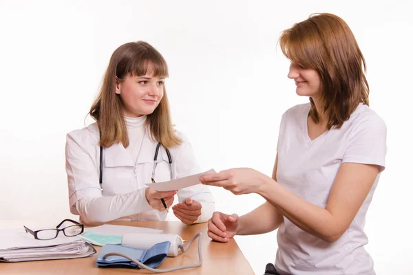 Il medico in ufficio estende al paziente una prescrizione o un certificato medico — Foto Stock