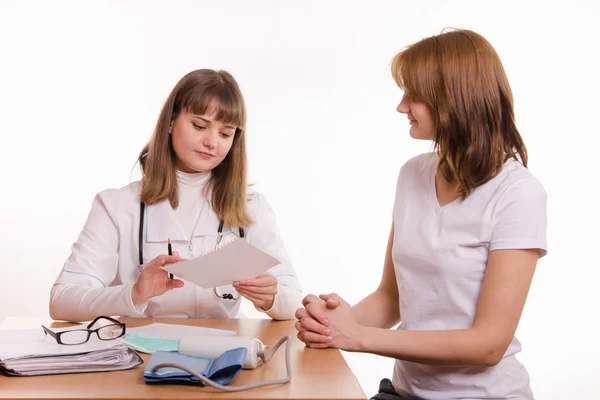 Médico con el paciente en su consultorio mirando el papeleo — Foto de Stock
