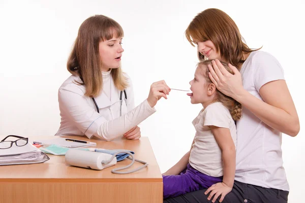 Pediatra mirando en la garganta del niño sentado en el regazo de la madre — Foto de Stock