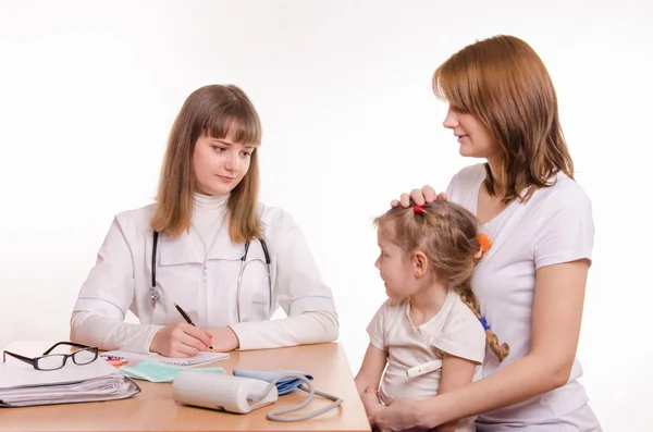 Kinderarzt hört sich die Beschwerden des kleinen Mädchens und ihrer Mutter an — Stockfoto