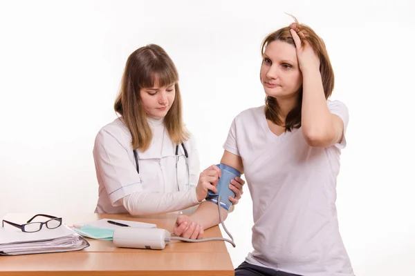 Therapist puts the cuff on the arm of the patient tonometer Stock Image