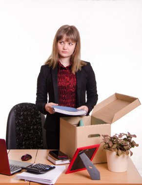 Dismissed girl collects his belongings in a box clipart