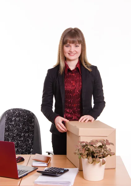 Chica sonriente en el escritorio de la oficina con una caja grande — Foto de Stock